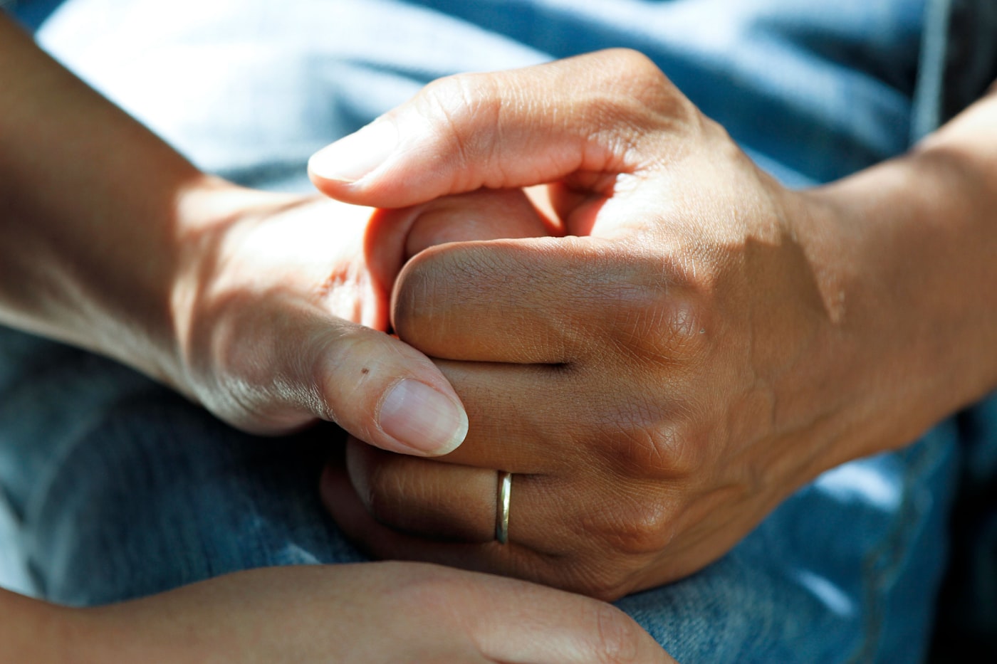 One person holding another's hands in support