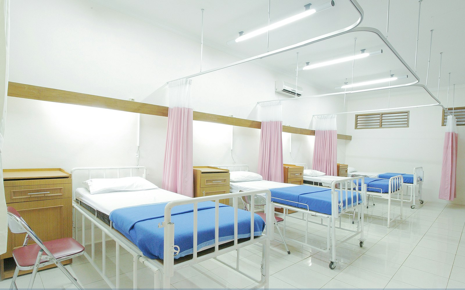 A bright, clean hospital ward with made-up beds