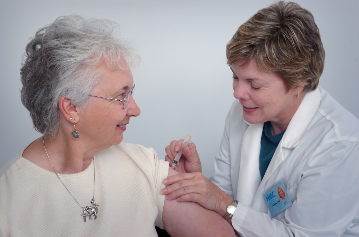 A nurse giving an older woman a vaccination